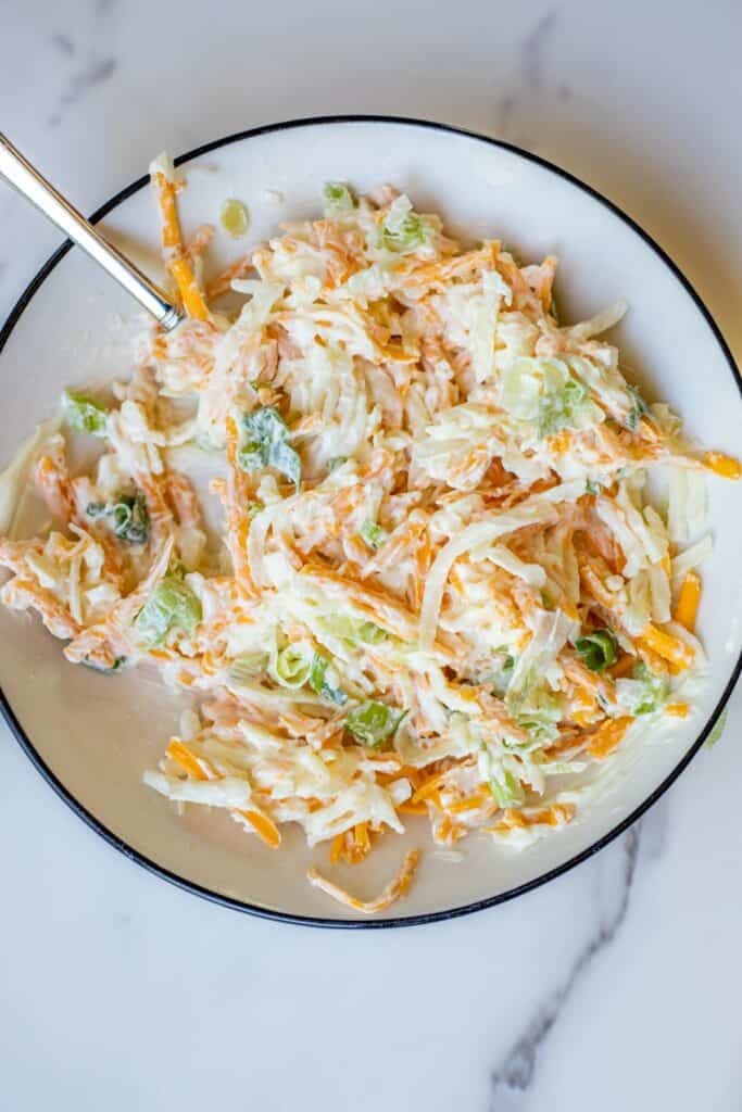 Cheese and mayo mixed together in a small bowl on a countertop.