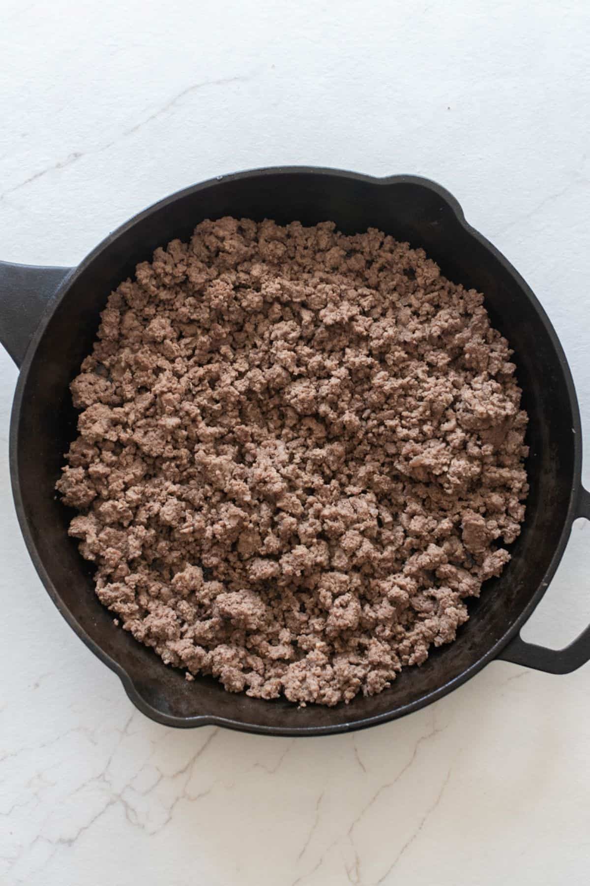 Cooked ground beef in a skillet.