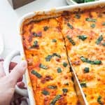 A baked zucchini lasagna being sliced into with a knife.