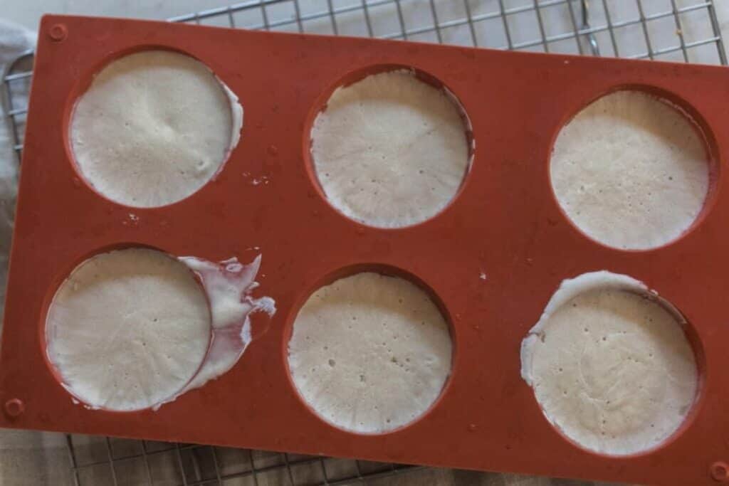 A silicone muffin mold with frozen sourdough starter in each hole.